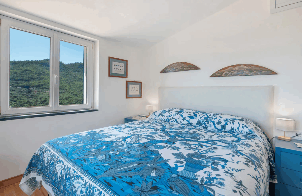Camera Blu double bed. Blue and white patterned bedding in a bright room with a view.