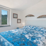 Camera Blu double bed. Blue and white patterned bedding in a bright room with a view.