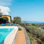 Casa di Pietra pool view. Swimming pool, sun loungers, and ocean view.