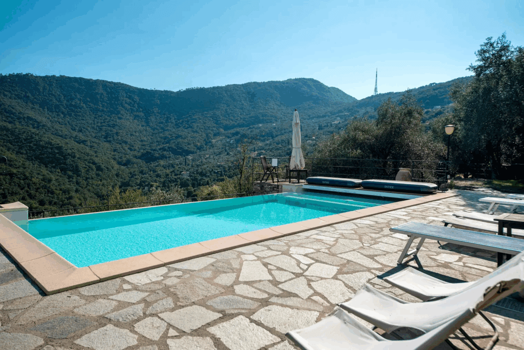 Casa di Pietra pool view. Swimming pool with mountain views and stone patio. Loungers for relaxation.